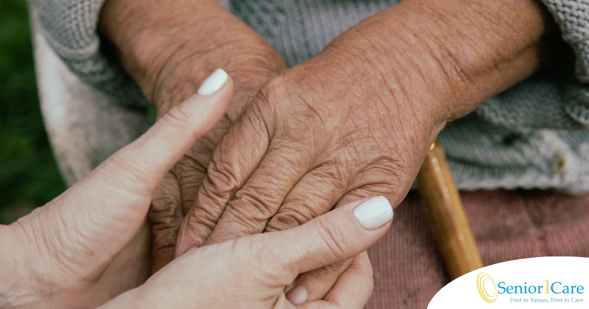 A caregiver holding an older adult's hands represents the support that hospice care can bring.