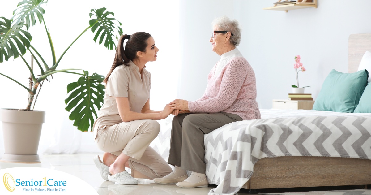 Communicating as a caregiver involves patiently and compassionately listening, as this caregiver is doing with her senior client.