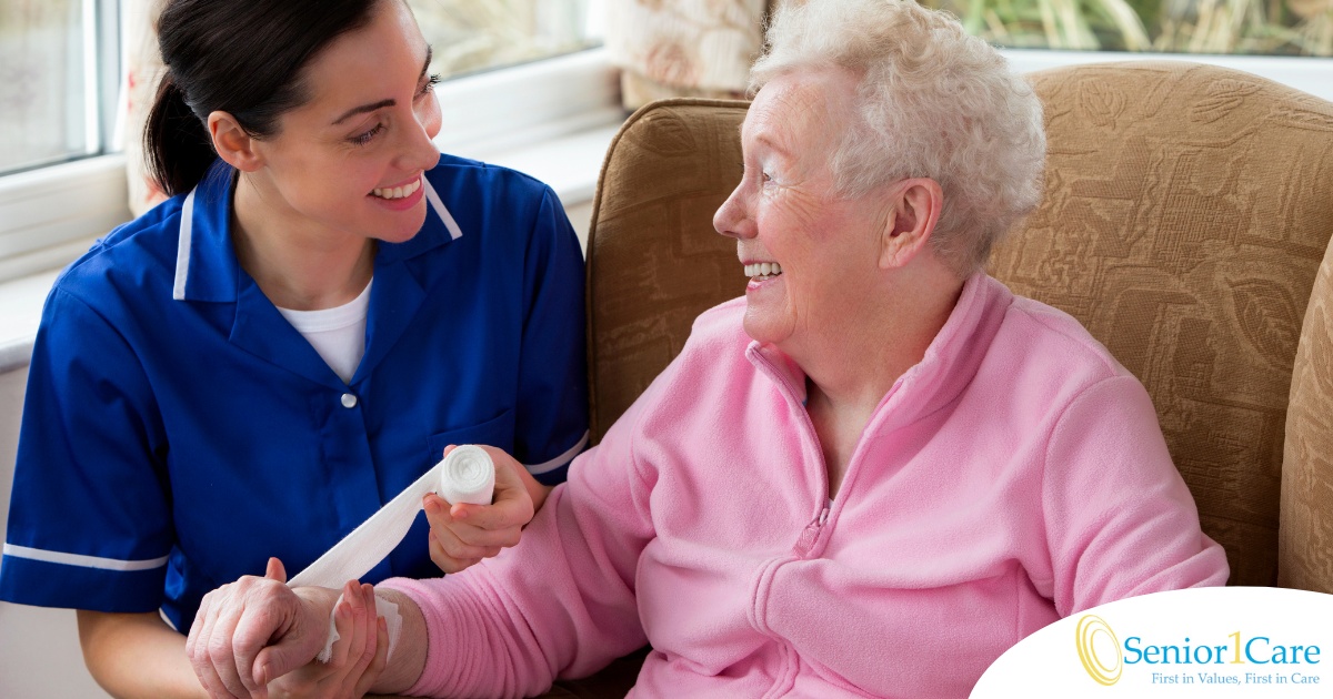 A caregiver demonstrates wound care by wrapping a senior client’s wound.